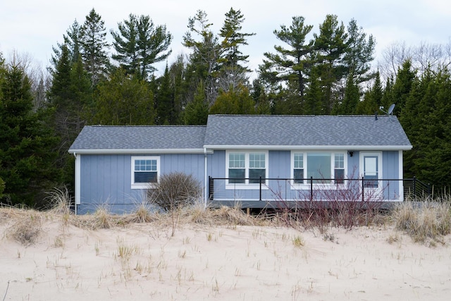 view of front of home featuring a wooden deck and a shingled roof