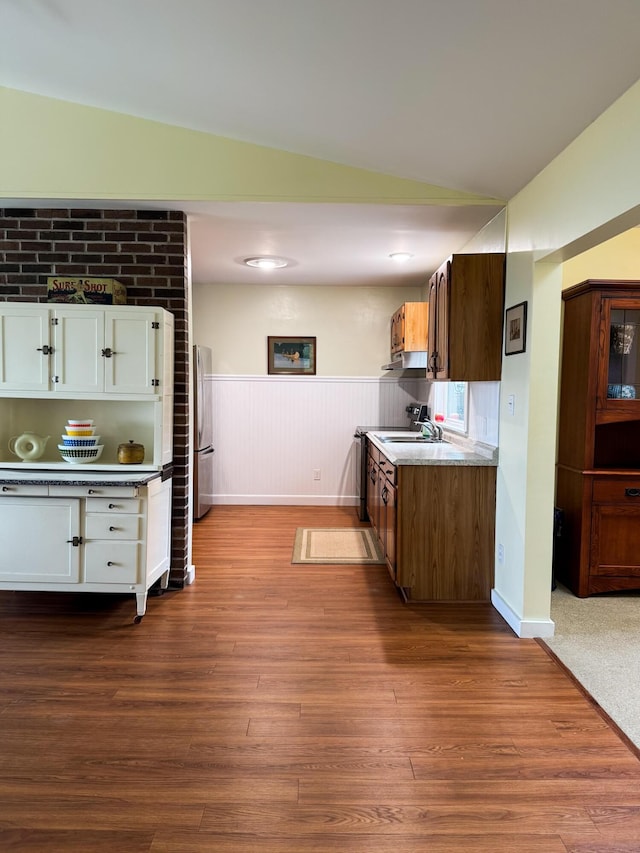 1220 N Lake Huron Shore Dr, Harrisville, MI 48740 - kitchen with light countertops, a wainscoted wall, freestanding refrigerator, lofted ceiling, and dark wood-type flooring