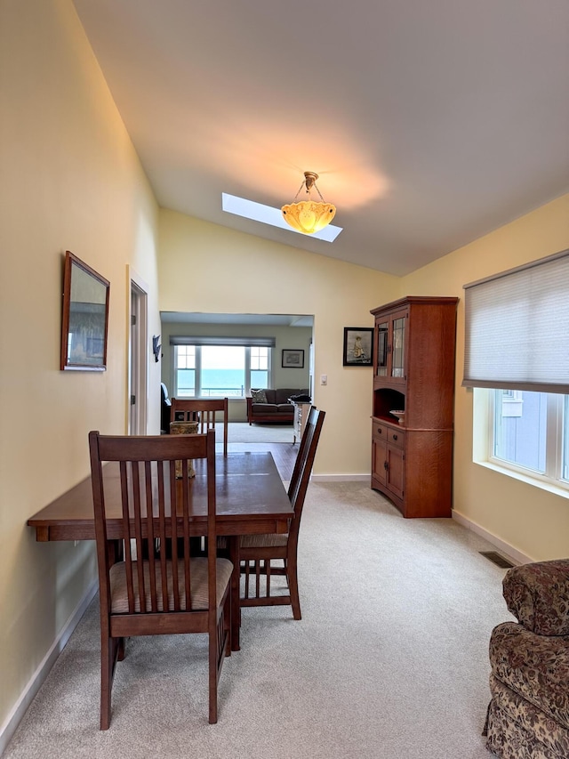1220 N Lake Huron Shore Dr, Harrisville, MI 48740 - dining room featuring baseboards, light colored carpet, and lofted ceiling
