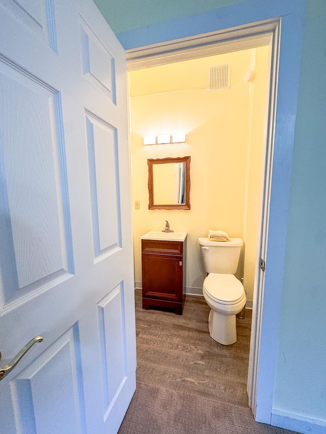 1220 N Lake Huron Shore Dr, Harrisville, MI 48740 - bathroom with vanity, toilet, wood finished floors, and visible vents