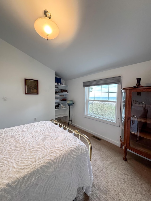 bedroom with baseboards, carpet, lofted ceiling, and visible vents