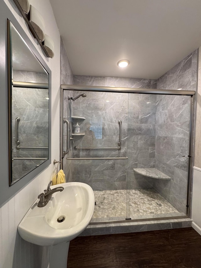 bathroom with wood finished floors and a stall shower
