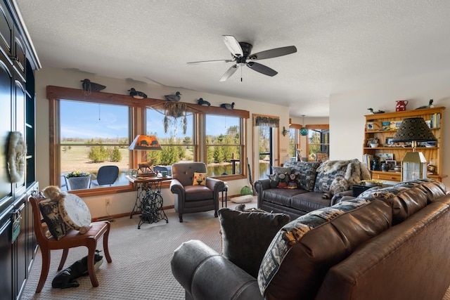 living area with light colored carpet, a textured ceiling, baseboards, and a ceiling fan