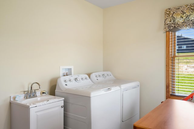 laundry room with independent washer and dryer and a sink