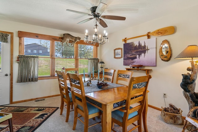 dining space with light colored carpet, ceiling fan with notable chandelier, baseboards, and visible vents