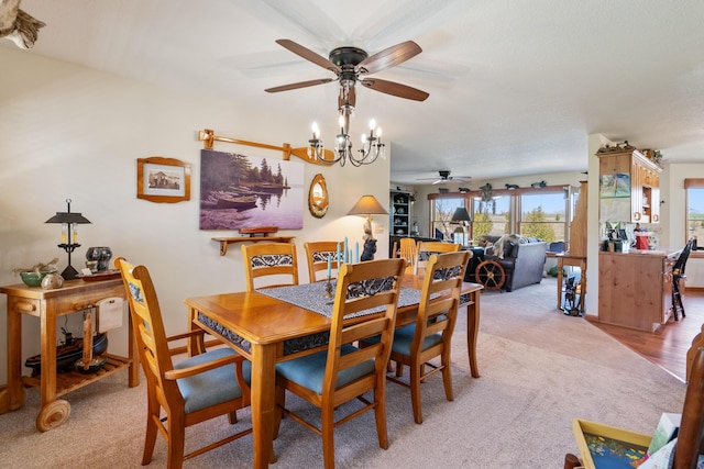 dining space with light colored carpet and a ceiling fan