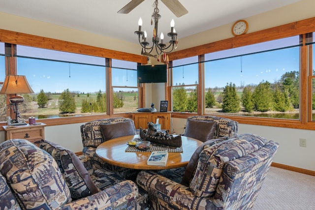 dining area with carpet floors, ceiling fan with notable chandelier, and baseboards