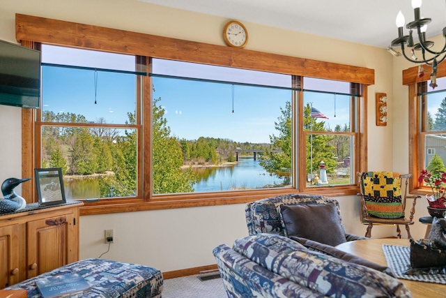 sunroom featuring a water view and a notable chandelier