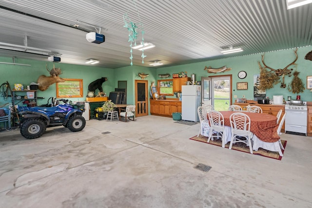 garage with freestanding refrigerator, visible vents, and a garage door opener