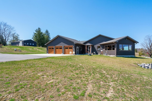 view of front of house featuring concrete driveway, a garage, and a front lawn