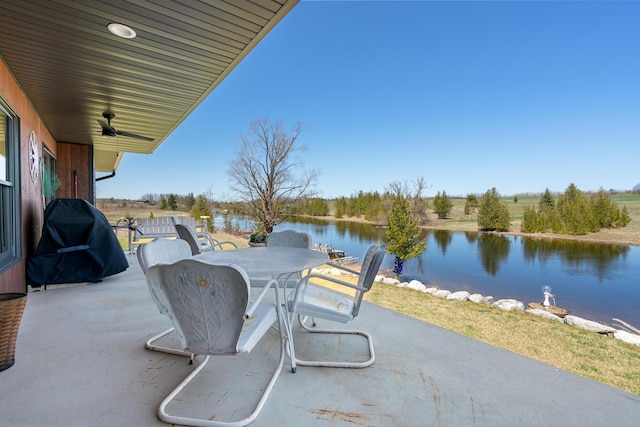 view of patio / terrace featuring a water view, area for grilling, outdoor dining area, and a ceiling fan