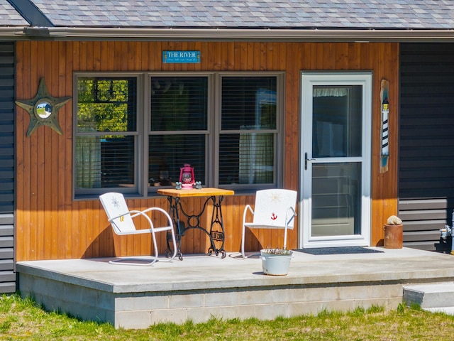 exterior space with covered porch and a shingled roof