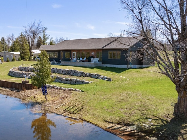 rear view of property featuring a yard, roof with shingles, and a patio area