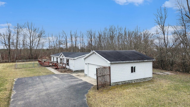 1580 Bancroft St, Cheboygan, MI 49721 - view of side of property with driveway, a garage, a wooden deck, a shingled roof, and a yard