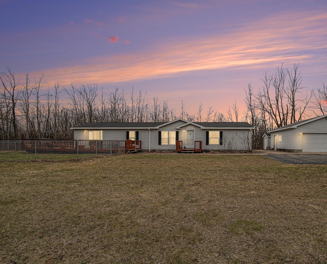 1580 Bancroft St, Cheboygan, MI 49721 - view of front of property featuring fence, a yard, a detached garage, and driveway