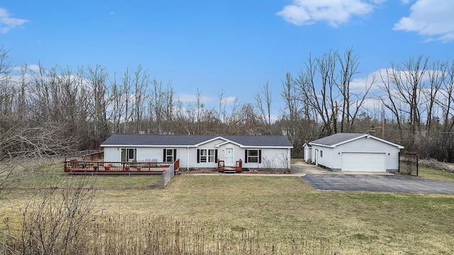 1580 Bancroft St, Cheboygan, MI 49721 - view of front of house featuring a deck, a front lawn, an outbuilding, and a garage