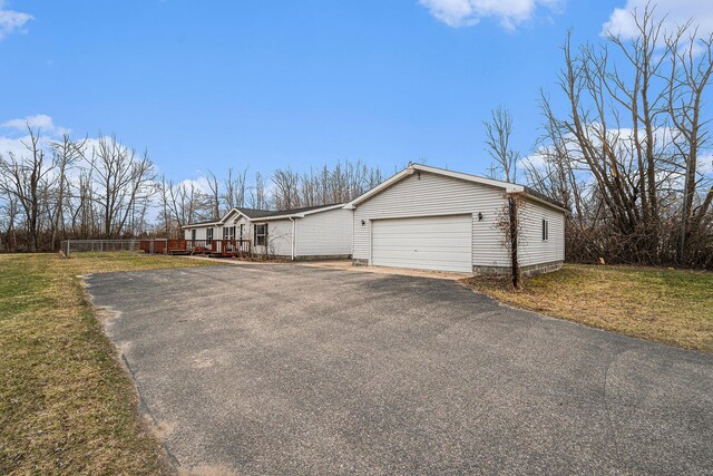 1580 Bancroft St, Cheboygan, MI 49721 - view of property exterior featuring a wooden deck, a yard, an attached garage, and driveway