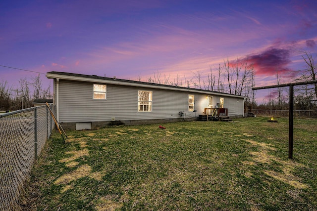 1580 Bancroft St, Cheboygan, MI 49721 - back of house at dusk featuring a fenced backyard and a yard
