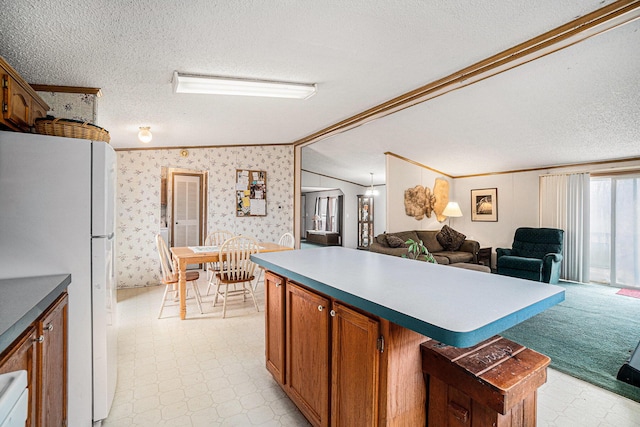 1580 Bancroft St, Cheboygan, MI 49721 - kitchen featuring wallpapered walls, light floors, ornamental molding, freestanding refrigerator, and a textured ceiling