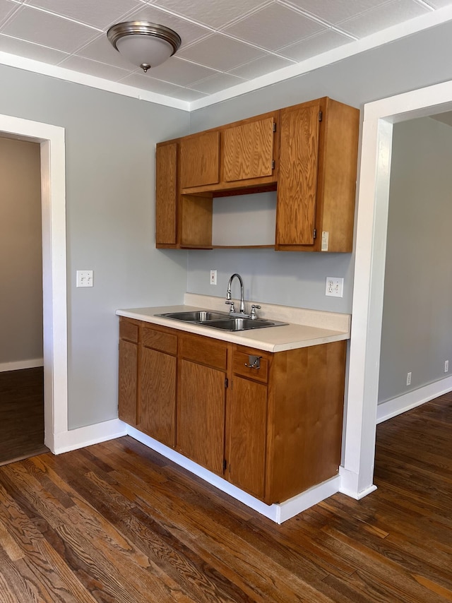 317 Pine Hill Ave, Cheboygan, MI 49721 - kitchen with a sink, dark wood-style flooring, brown cabinets, and baseboards