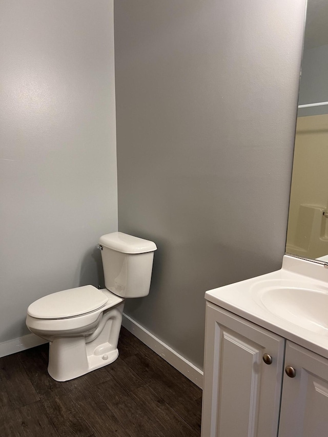 317 Pine Hill Ave, Cheboygan, MI 49721 - bathroom with baseboards, toilet, vanity, and wood finished floors