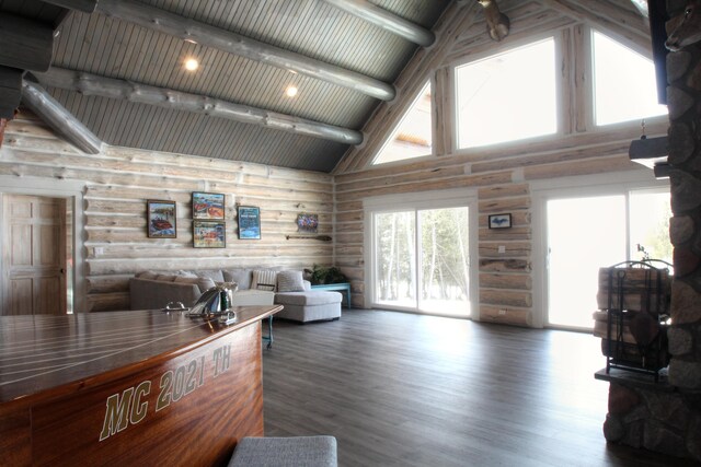 living room featuring beam ceiling, log walls, wood finished floors, and high vaulted ceiling