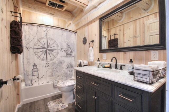 full bathroom with vanity, shower / bath combination with curtain, toilet, wood walls, and wood finished floors
