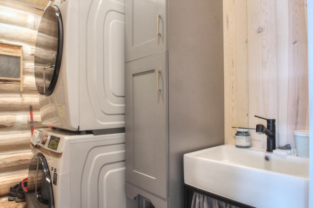 laundry room with stacked washer / dryer, a sink, and laundry area