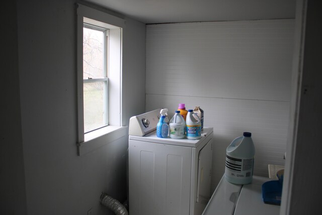 clothes washing area featuring washer / clothes dryer, laundry area, and a healthy amount of sunlight