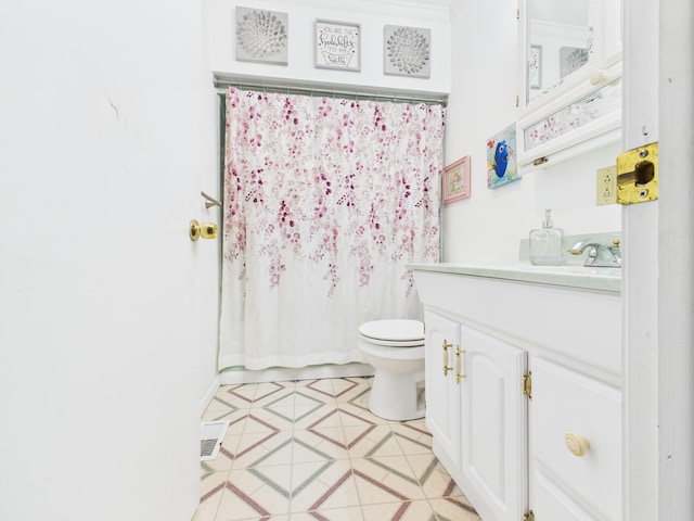 bathroom with toilet, vanity, a shower with curtain, and tile patterned flooring