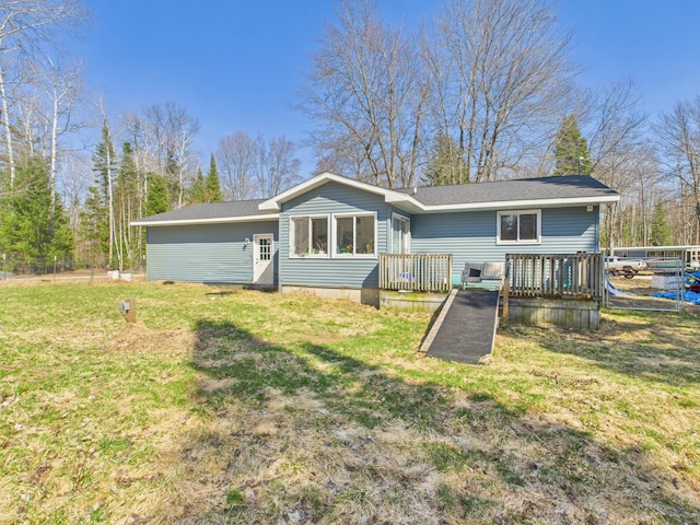 back of house featuring a lawn and a wooden deck