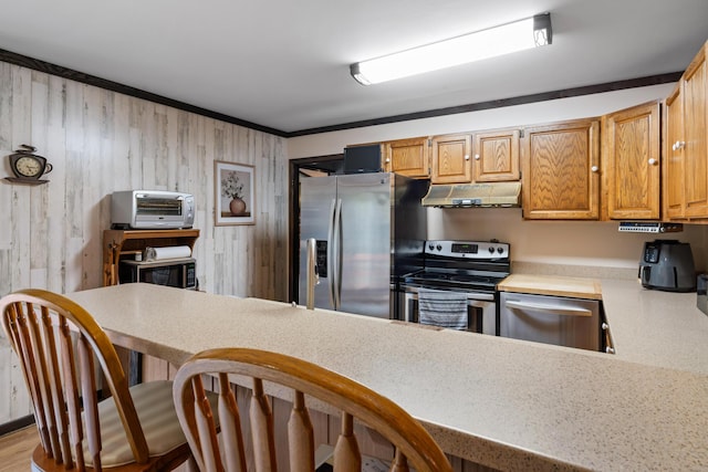 198 W Spruce St, Saint Ignace, MI 49781 - kitchen featuring stainless steel appliances, a kitchen breakfast bar, a toaster, light countertops, and under cabinet range hood
