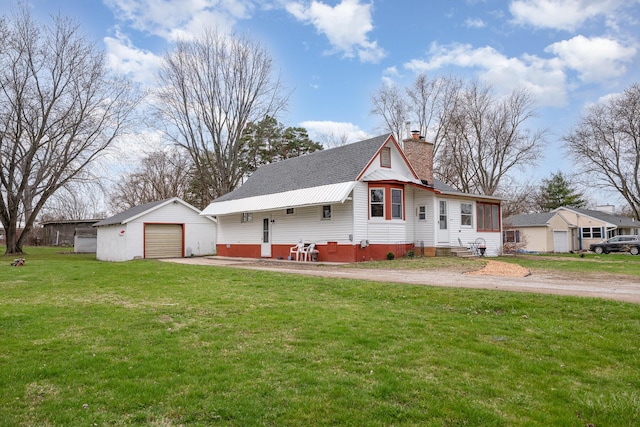 view of front of home featuring a garage, an outdoor structure, driveway, a chimney, and entry steps