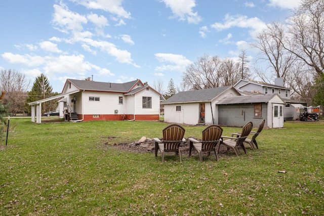 rear view of house featuring an outdoor structure, a yard, a chimney, and an outdoor fire pit