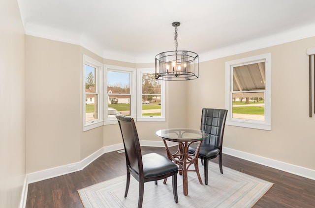 dining room with dark wood finished floors, an inviting chandelier, and a wealth of natural light
