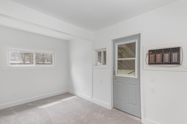 spare room with light carpet, an AC wall unit, and baseboards