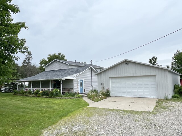 view of front of property with a garage, roof with shingles, a front lawn, and covered porch