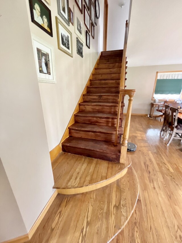 stairs with wood finished floors and baseboards