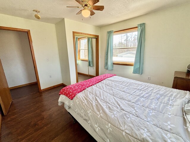 bedroom featuring a textured ceiling, baseboards, a ceiling fan, wood finished floors, and a closet