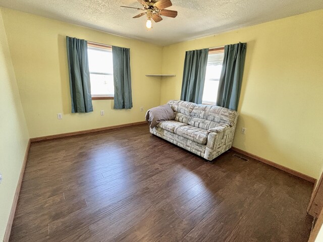 sitting room featuring ceiling fan, wood finished floors, visible vents, and plenty of natural light