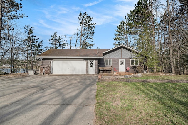 view of front of house featuring an attached garage, concrete driveway, and a front yard