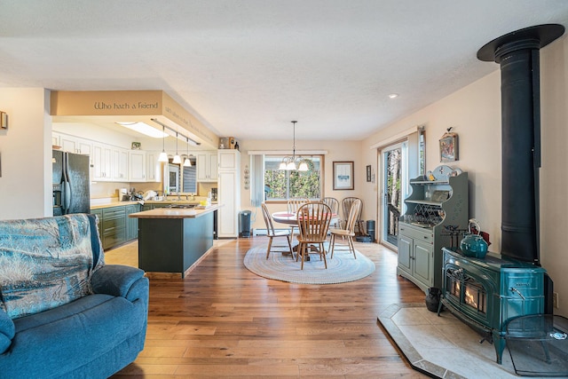 interior space with recessed lighting, a wood stove, light wood-style flooring, and an inviting chandelier