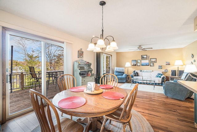 dining space with light wood-type flooring and ceiling fan with notable chandelier