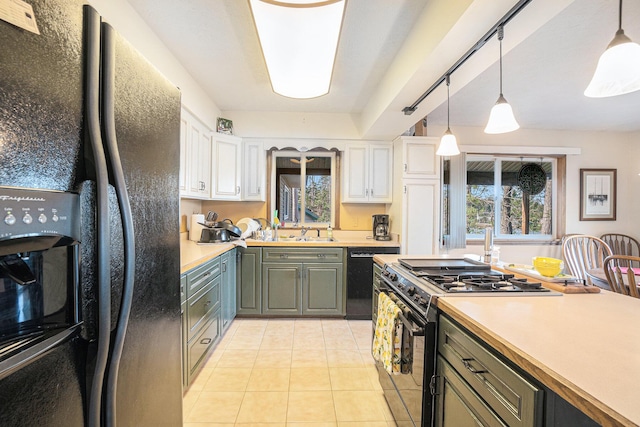 kitchen with a sink, light countertops, black appliances, and white cabinetry