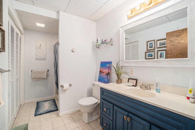bathroom featuring vanity, toilet, tile patterned floors, baseboards, and a shower