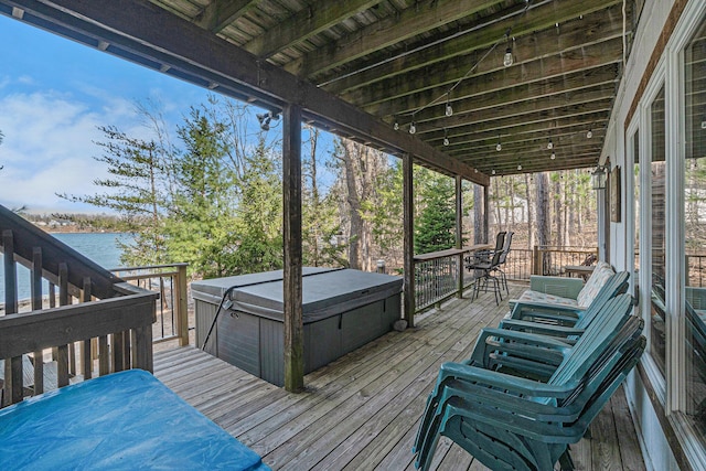 wooden terrace with a water view and a hot tub