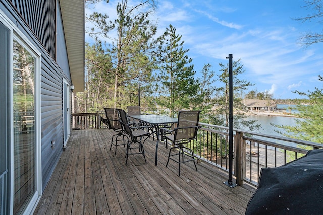 wooden deck featuring outdoor dining space and a water view