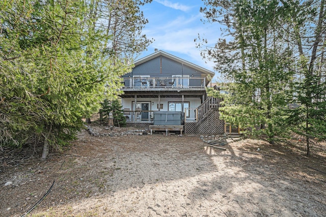 rear view of property with a deck and stairs