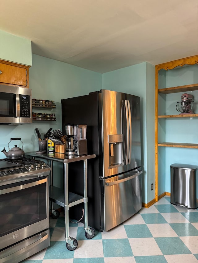 kitchen with light floors, brown cabinetry, and stainless steel appliances