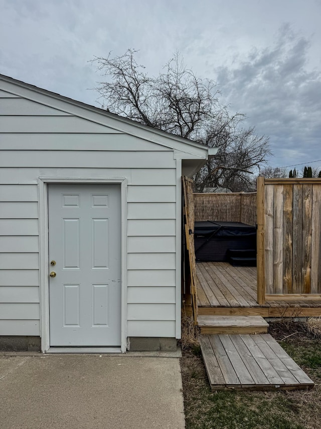 view of outdoor structure featuring fence and a jacuzzi